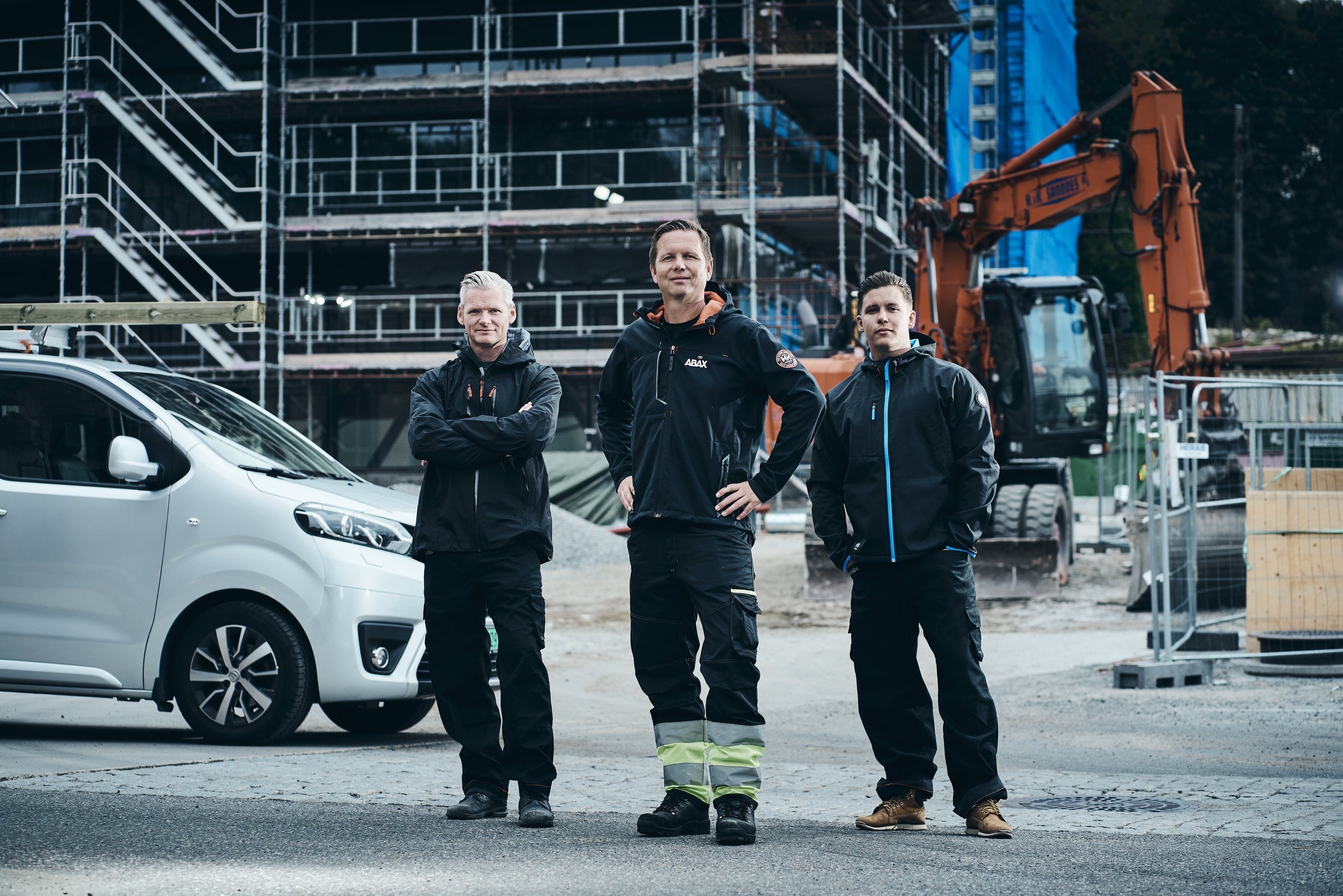 Ett team på tre vid sin bil på en byggarbetsplats